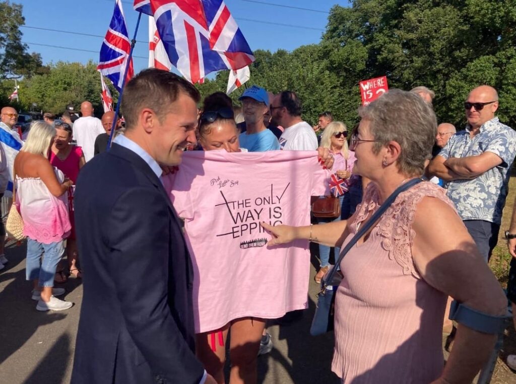 Photos posted by Jenrick show him interacting with demonstrators, including a woman with a t shirt that says "Send them home".
